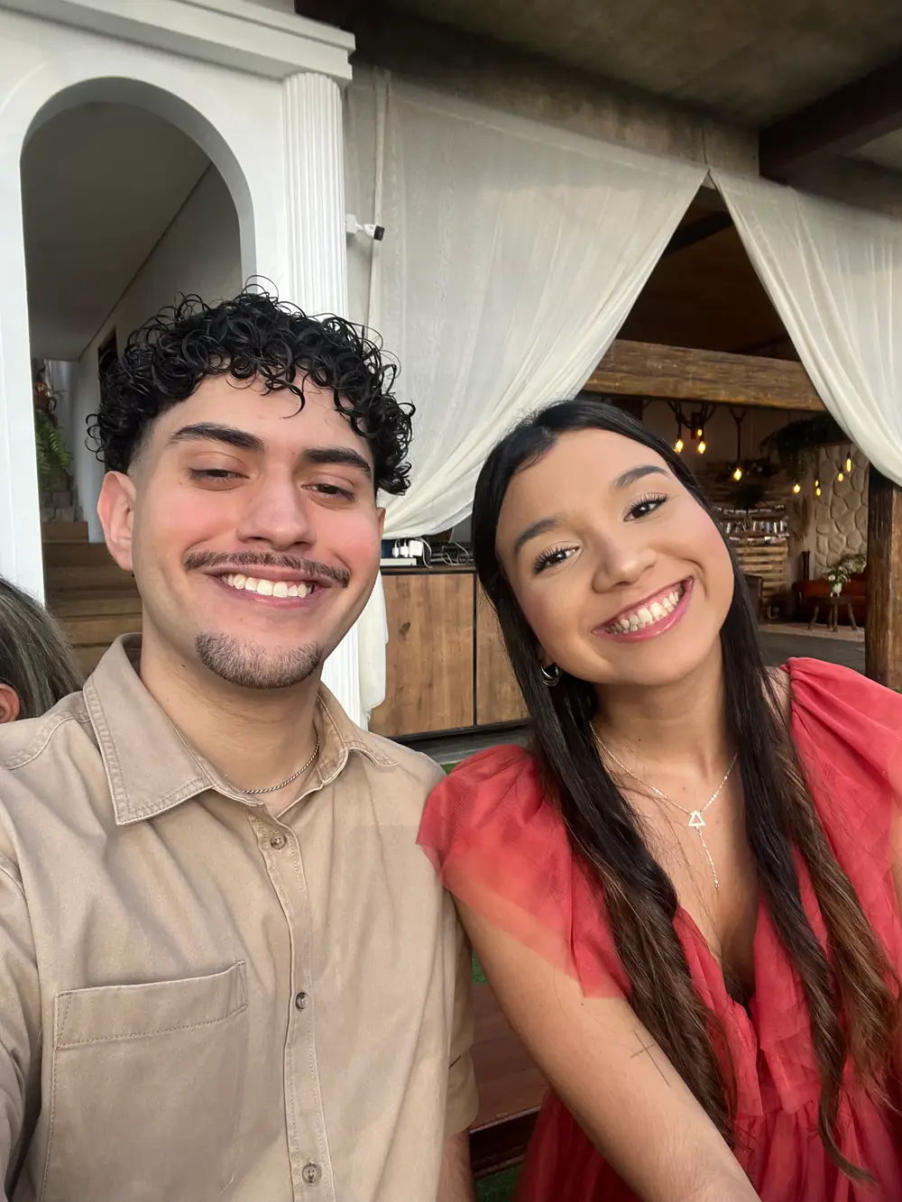Os dois num restaurante de dia, ela de vestido rosa